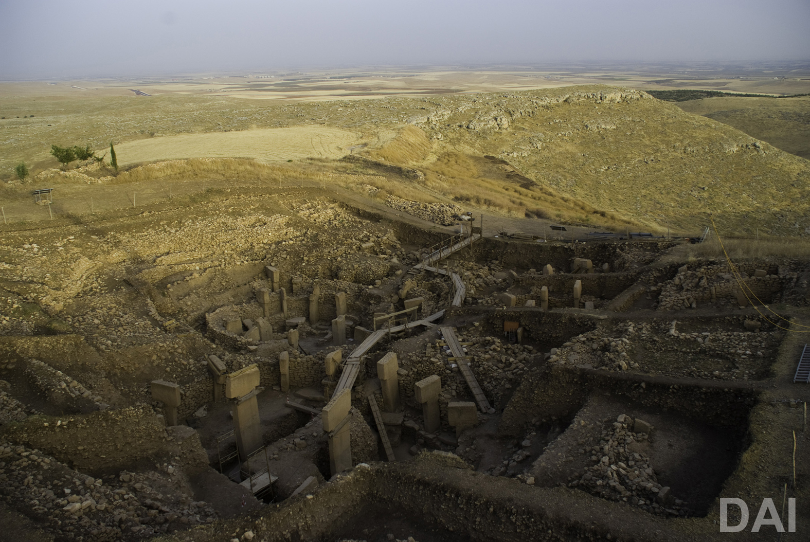 Wide view of Göbekli Tepe’s excavated stone enclosures and T-shaped pillars